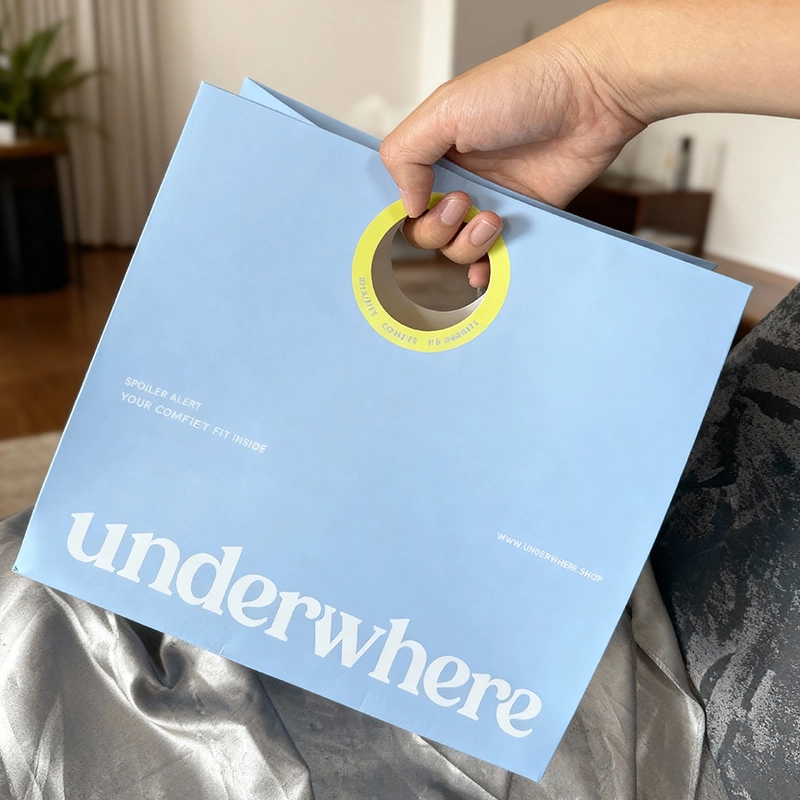 Blue die-cut paper bag with round handle and custom print