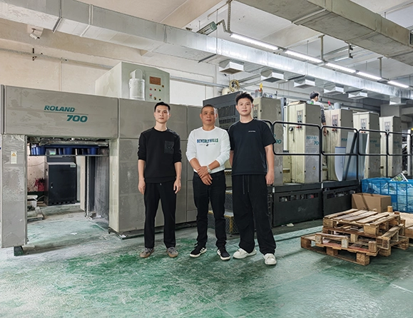 HS Packfactory production team beside an offset printing press